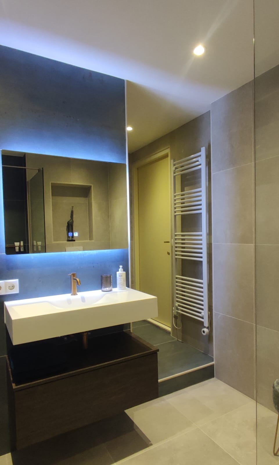 De Tegel Suite badkamer met regendouche en bronzen accenten